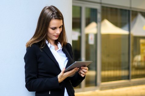 Smiling businesswoman using a digital tablet outdoor